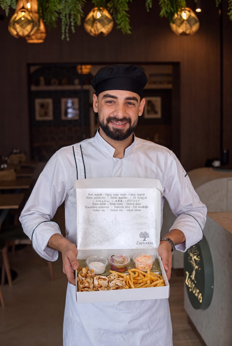 Zaytouna séf nyitott elviteles dobozzal: shawarma tekercsek, sültkrumpli, mártogatósok