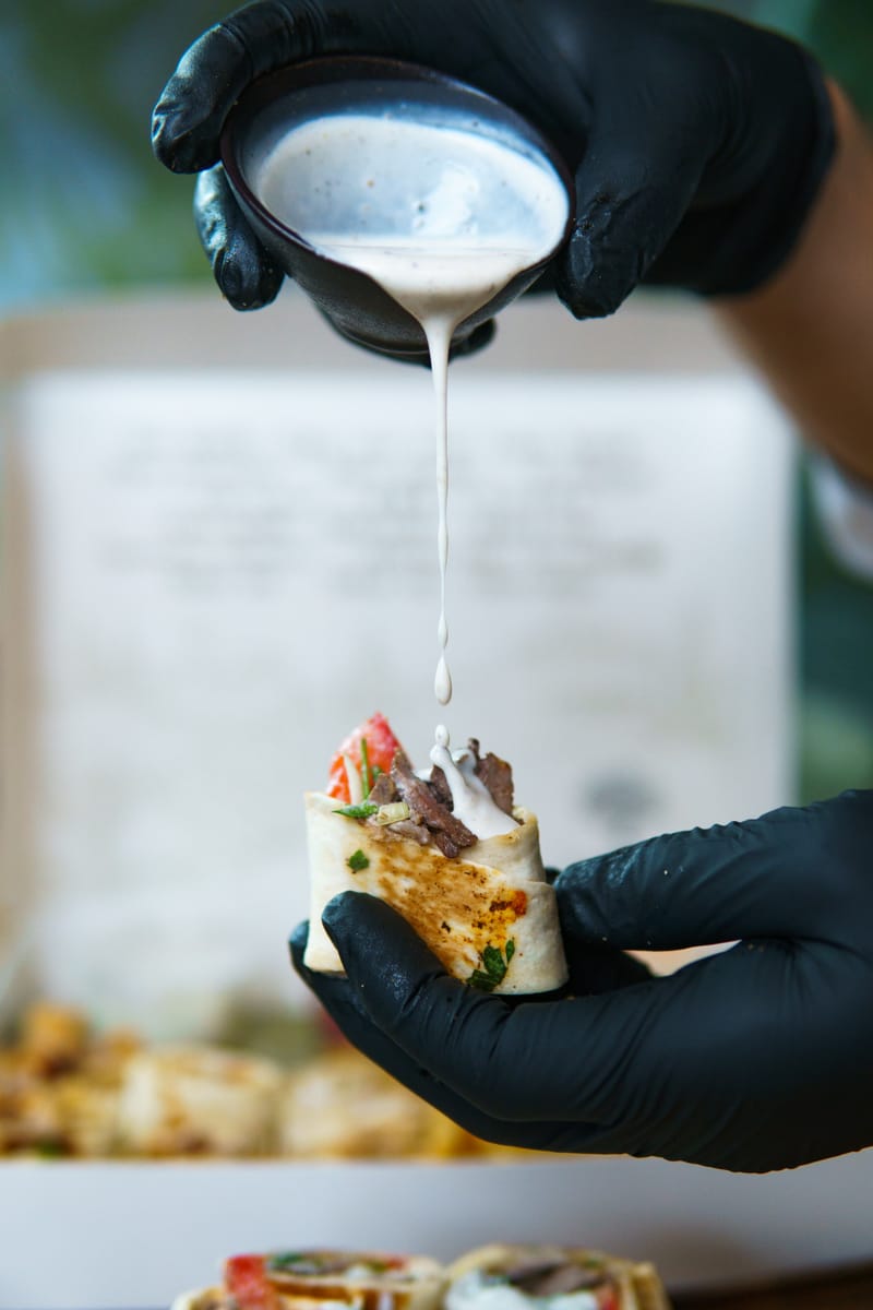 Fokhagymás szósz csorog egy frissen sült shawarma tekercsre